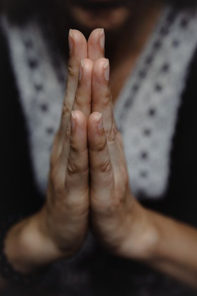 Close-up of a person's hands in a meditative mudra position.